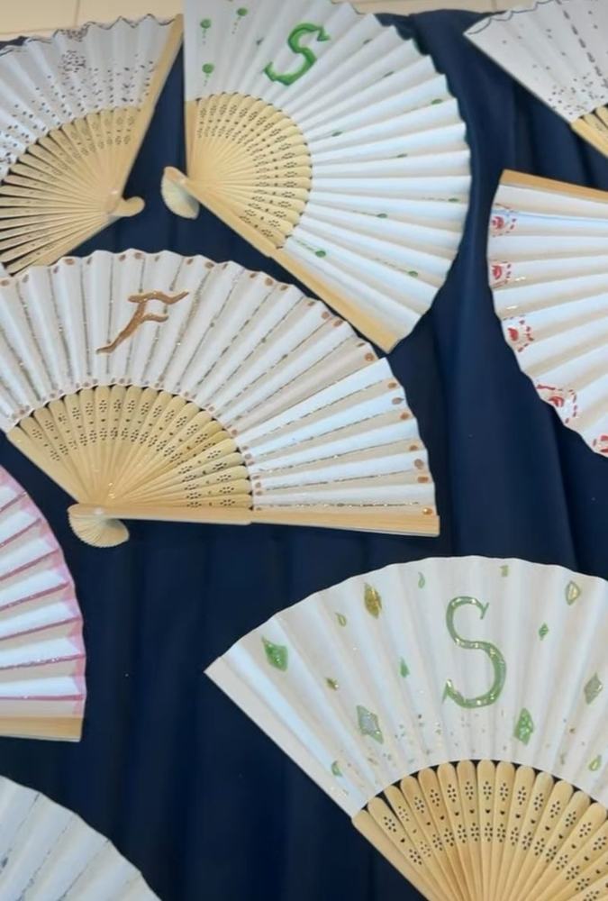 A table of personalised hand-painted fans
