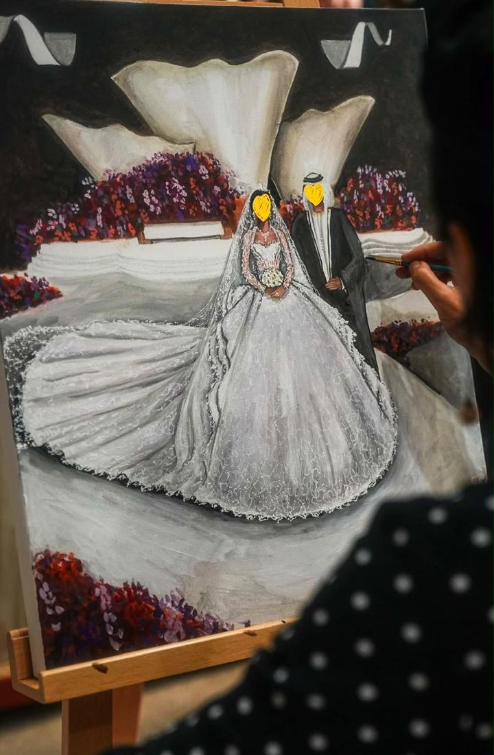Rania painting the bride and groom on canvas