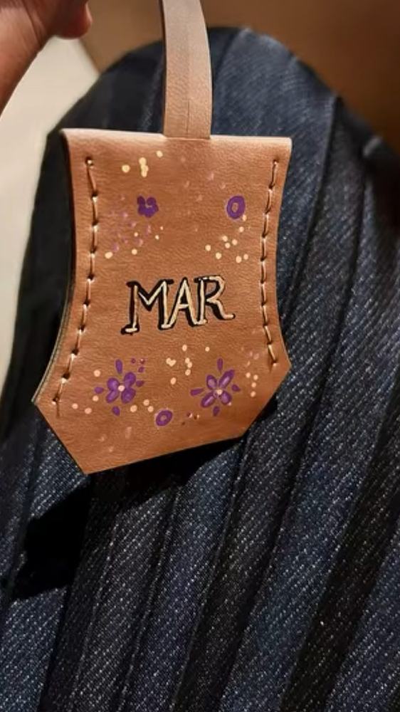 Leather bag tag painted with a name and flowers